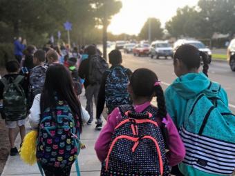 diverse young students walking to school